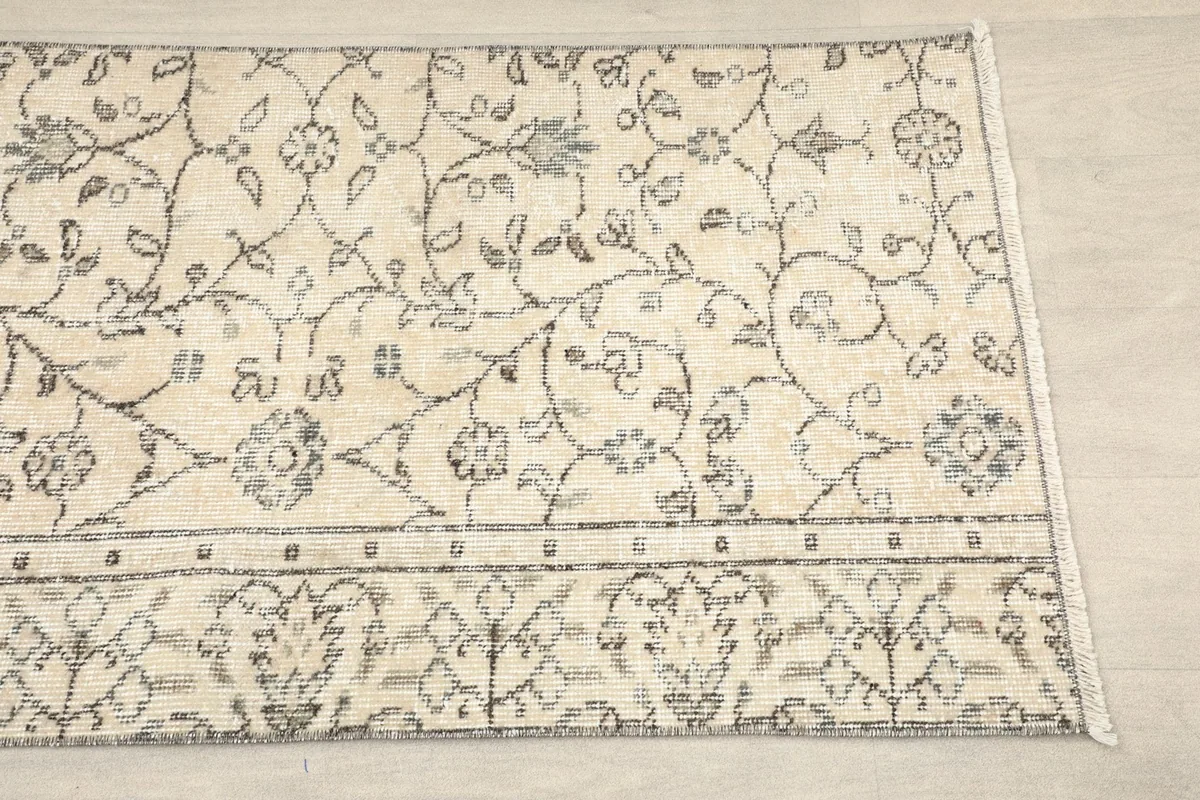Close-up of the runner rug's border and central floral pattern, showing texture and design