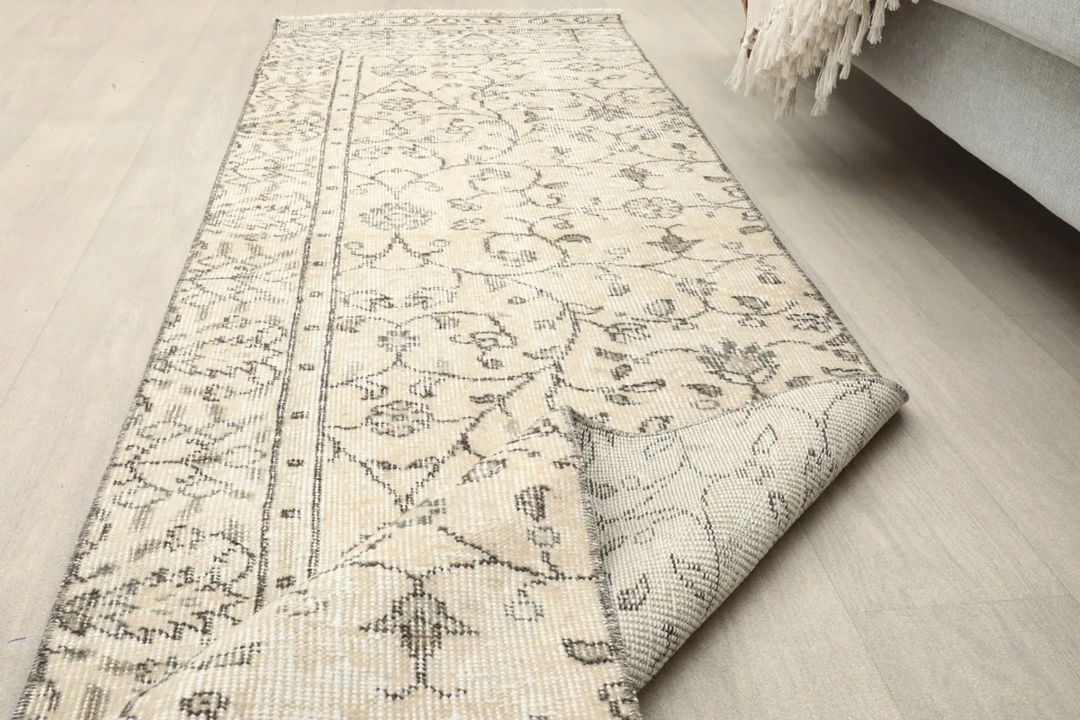 The runner rug with a corner folded over, showing both the front and back textures in a room setting