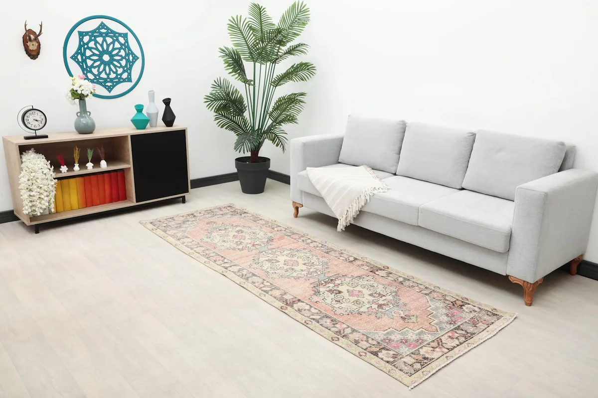 Wide view of the rust runner rug in a modern living space with a sofa and console table.