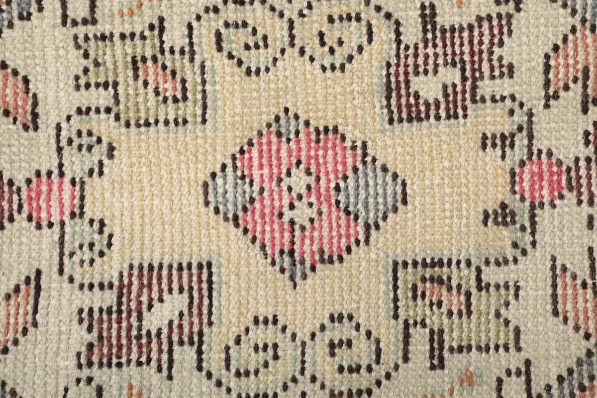 Macro shot of the rug's low wool pile, revealing the hand-knotted texture and intricate weaving.