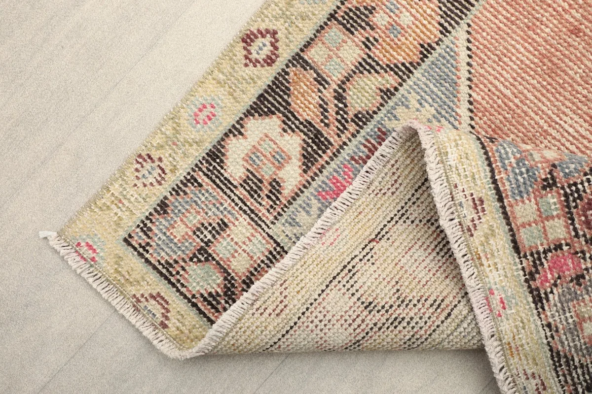 View of the rug's cotton foundation and reverse side, demonstrating its hand-knotted construction.