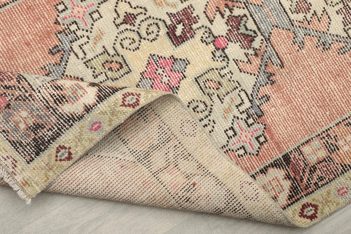 The rug folded to show the thickness and the back of the rug, highlighting its material and weave.