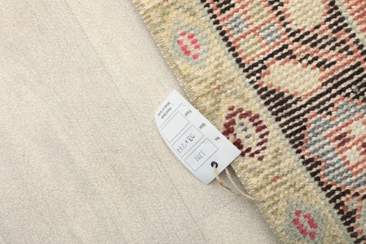 Tag showing the rug's size and origin, attached to the corner of the hand-knotted runner.