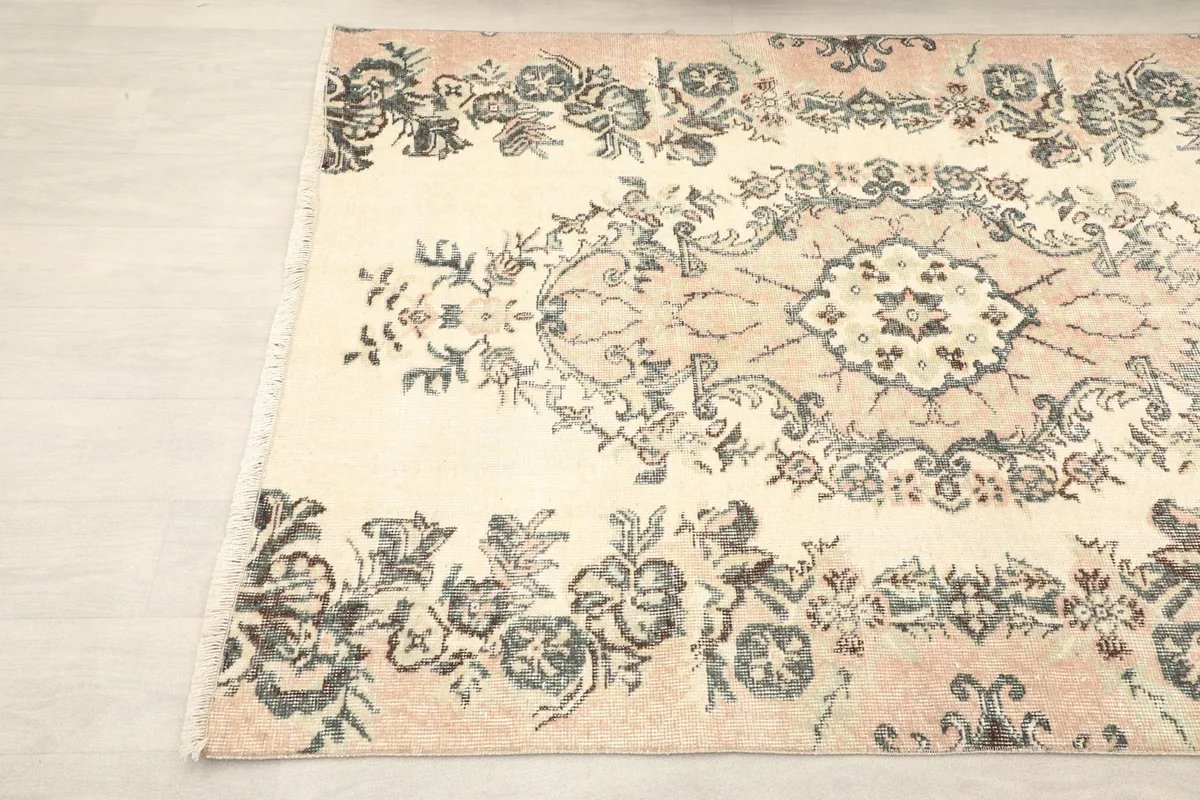 Detailed view of the central medallion with its intricate cream, rose, and gray motifs