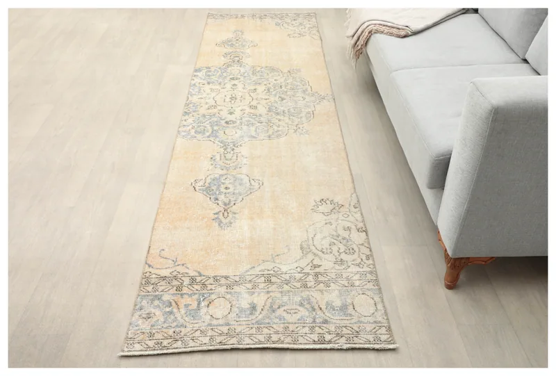 Full top view of the 2'7" x 9'6" beige and blue vintage runner rug on a white background.