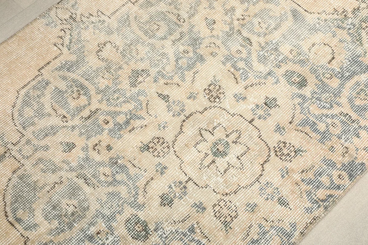 Overhead close-up of the central floral medallion and surrounding patterns on the beige field.