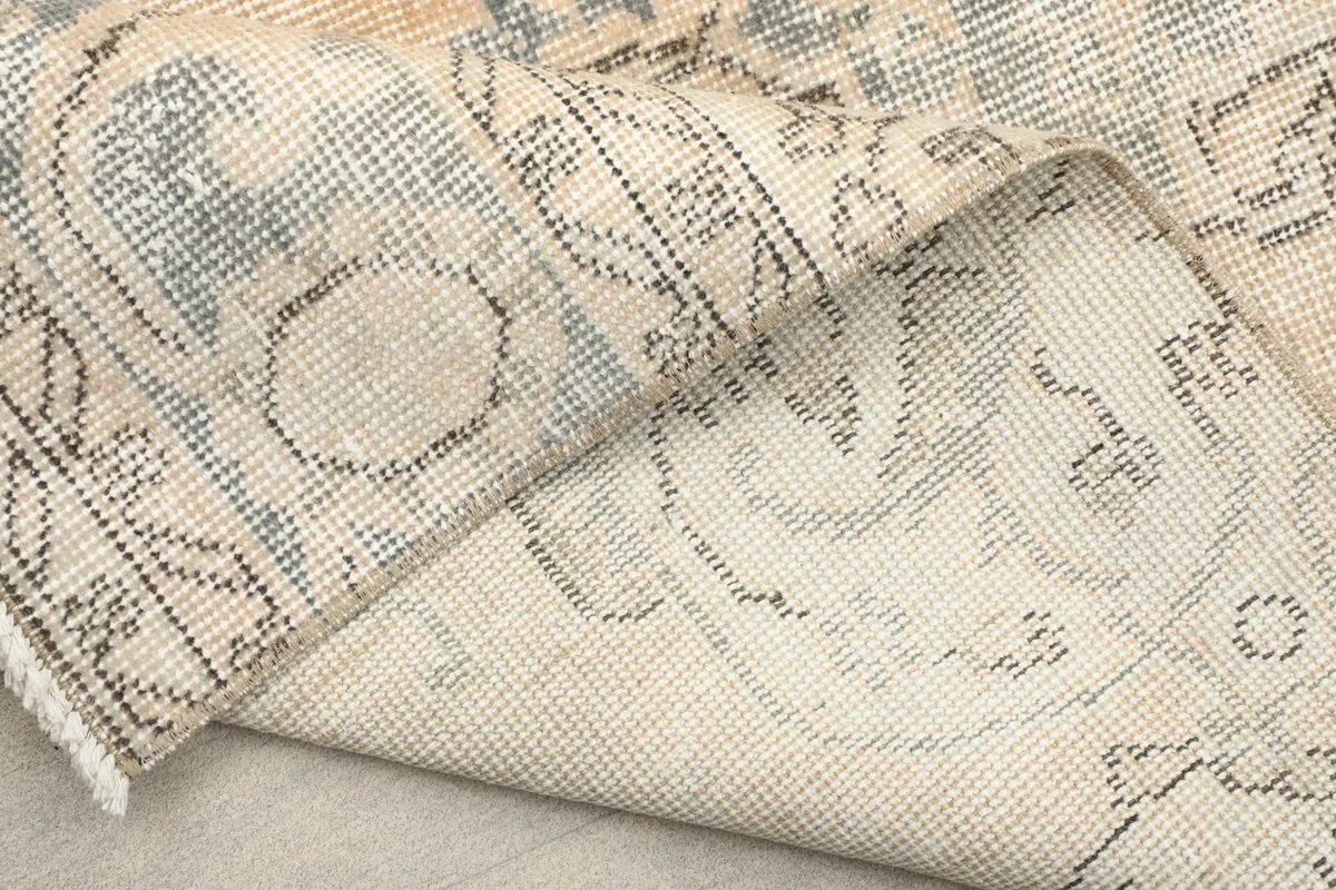View of the rug folded to show the flexibility and the reverse side of the hand-knotted construction.