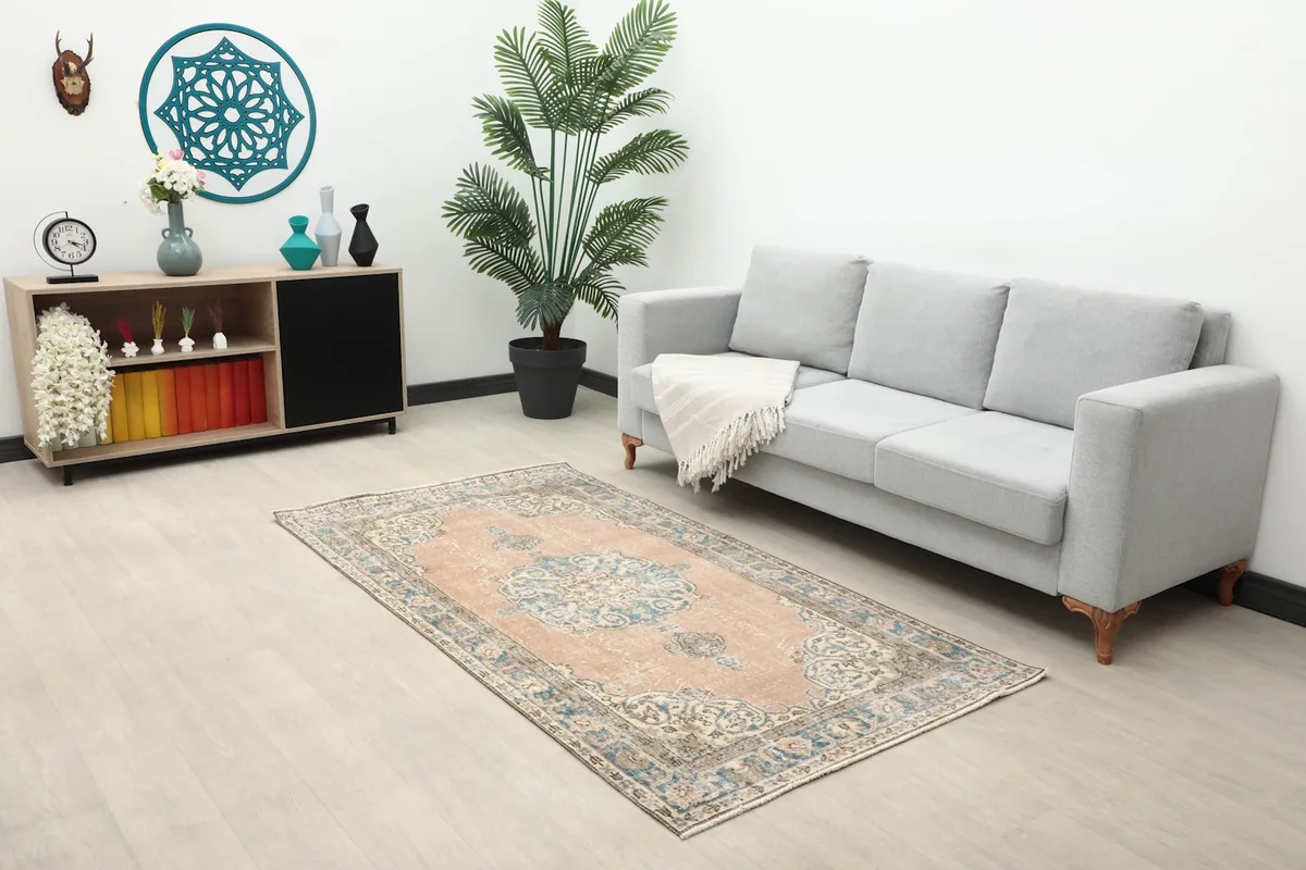 Full room view showing the rose and blue vintage rug placed in a living area