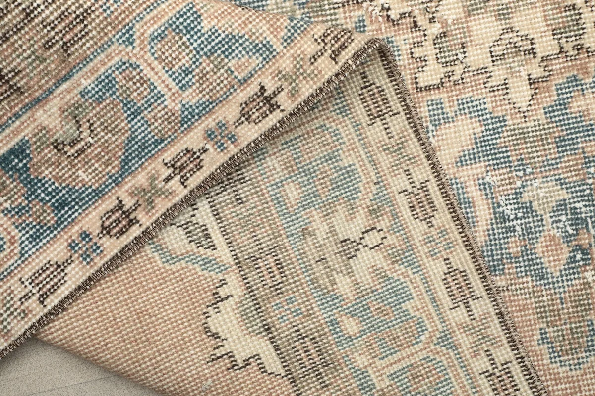 Close-up of the back of the hand-knotted wool rug, revealing the cotton foundation