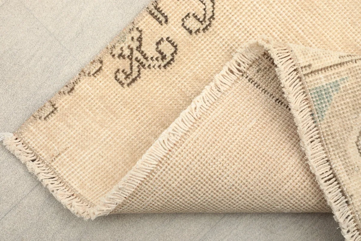 Underside view of the runner rug, showing the cotton foundation and hand-knotted construction.