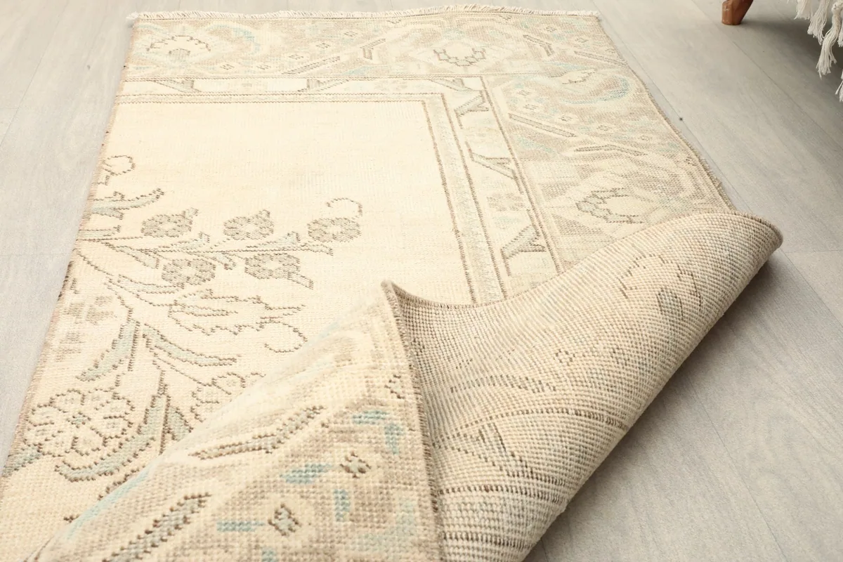 Rug folded to display both the top surface with patterns and the reverse side of the hand-knotted weave.