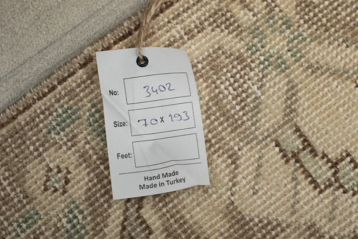 Close-up of the care tag attached to the rug, showing its size 70x193 cm and 'Made in Turkey' label.