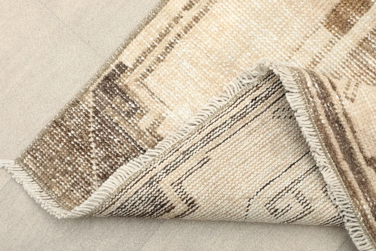View of the rug's low pile, showing the fiber texture and the subtle color shifts.