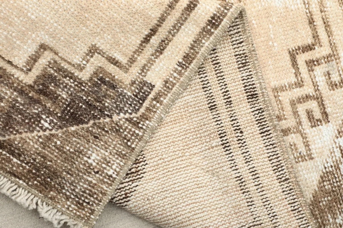 Close-up of the rug's cotton foundation and the reverse side of the hand-knotted construction.