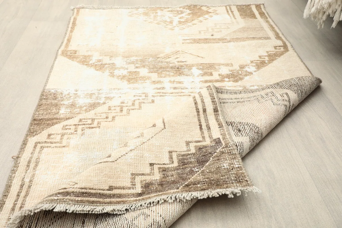 The rug partially folded, highlighting its flexibility and the woven texture of the backing.