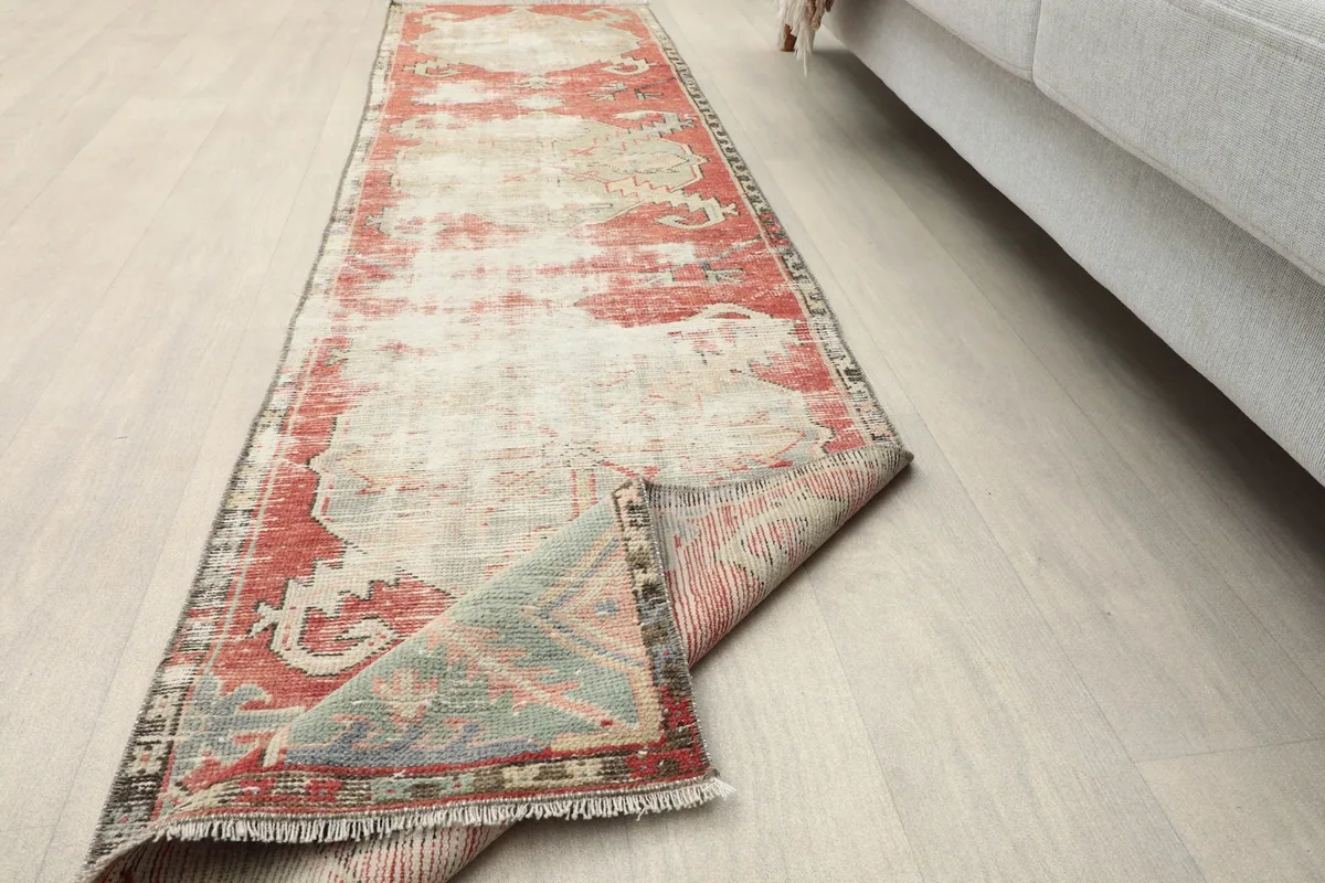 The runner rug partially folded, illustrating its flexibility and thickness of the wool pile.