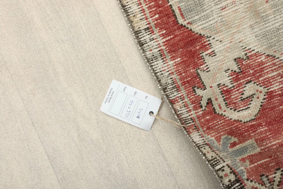 Overhead view of a corner of the rug with the product tag displaying size and material information.