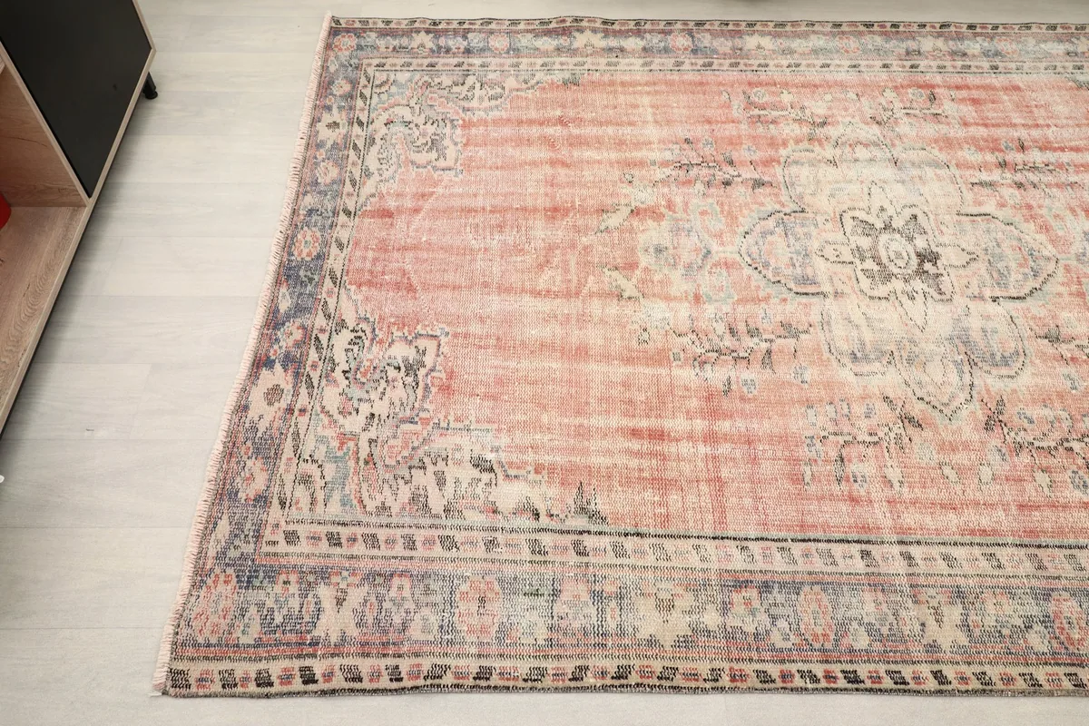 Detailed view of the opposite corner and border of the hand-knotted rose and gray rug