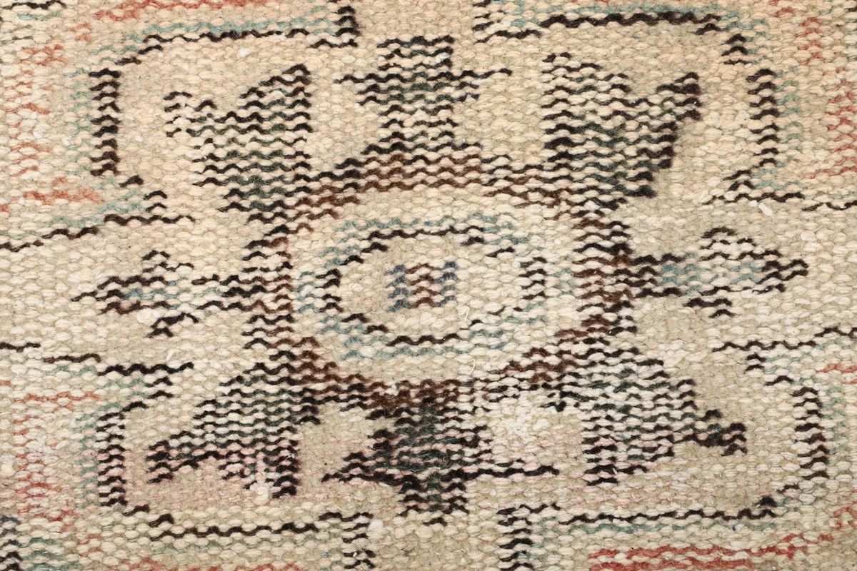 Extreme close-up of the wool pile and knotting, revealing the texture and low pile height