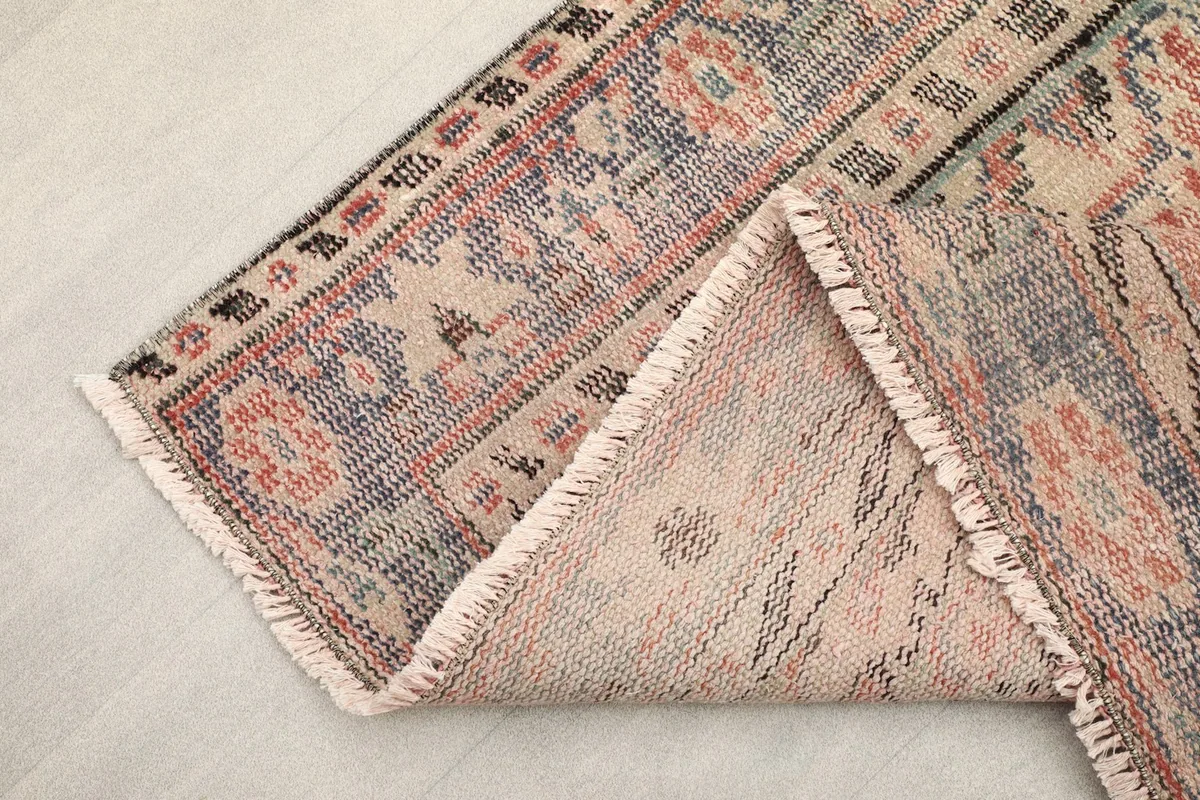 Another view of the folded rug edge, highlighting the fringe and hand-knotted construction