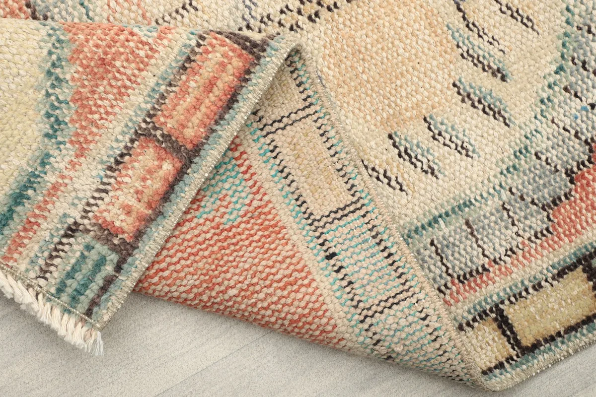 Folded corner of the rug, showing the reverse side and construction