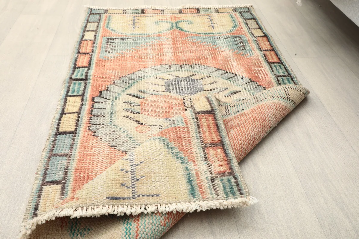 Rug partially folded, displaying both the front design and the back of the rug