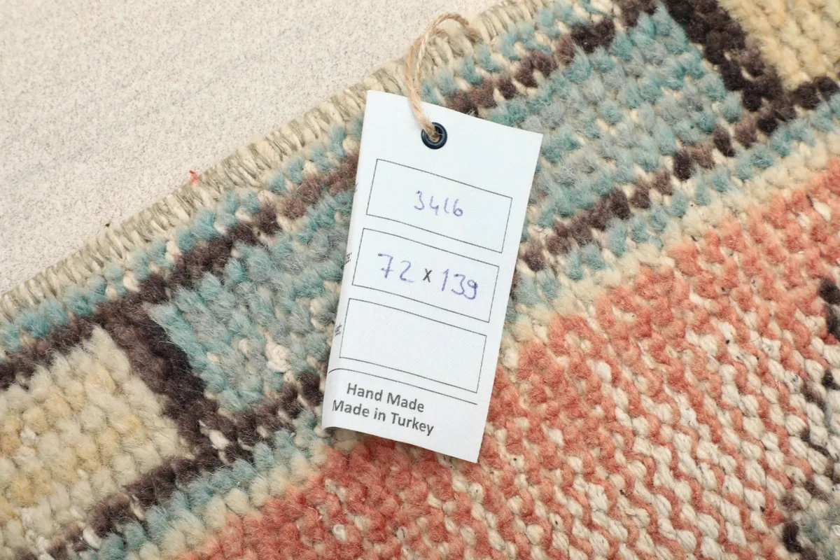 Close-up of the tag showing the rug's dimensions and 'Hand Made in Turkey' on the reverse