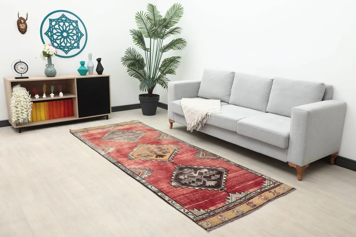 Wide shot of the red runner in a living room setting with a sofa and decor.