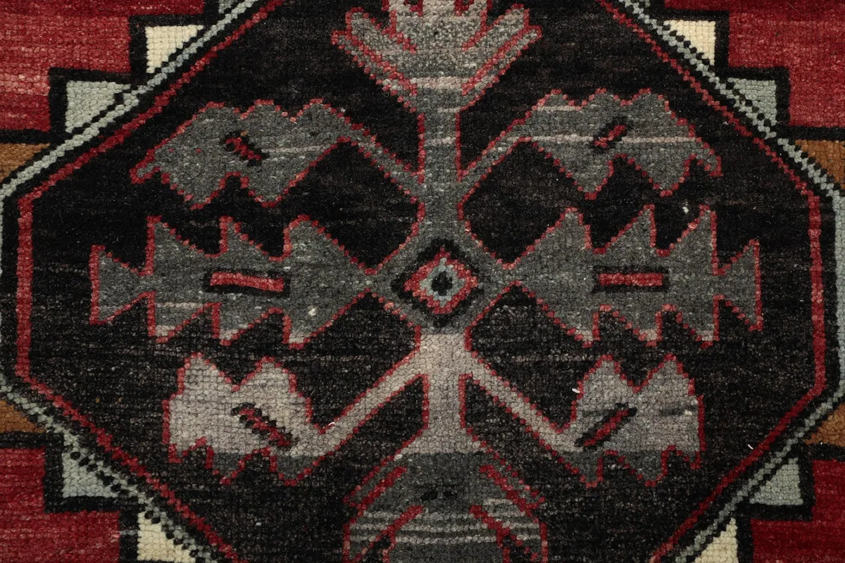 Extreme close-up of a tribal geometric motif with black, gray, and red details.