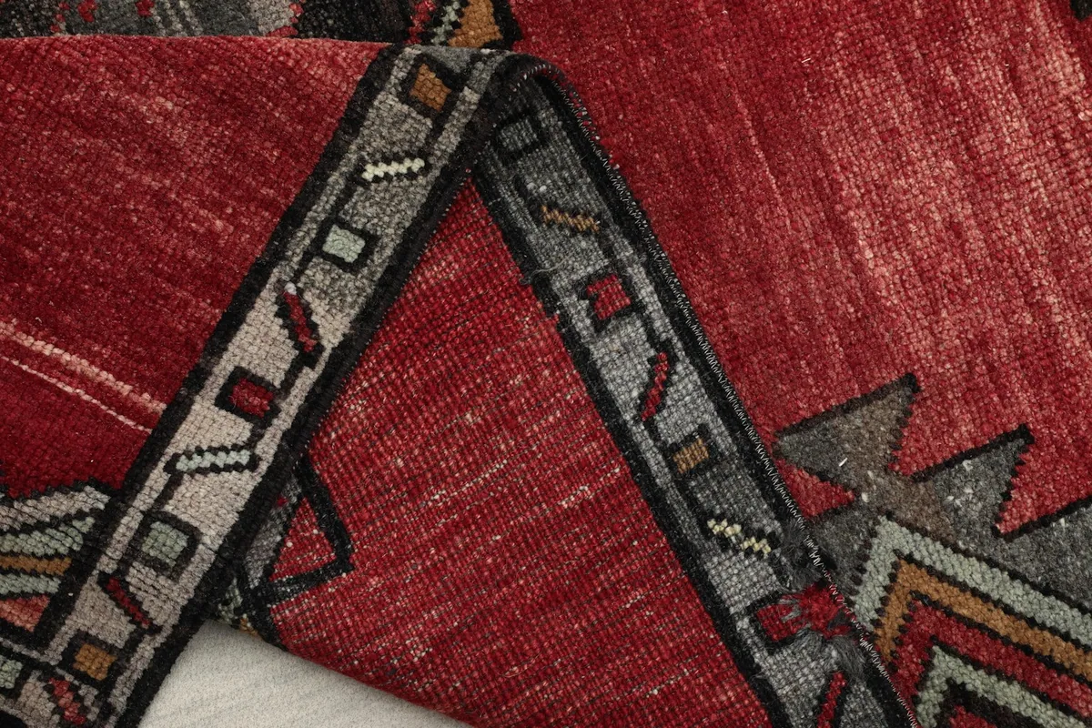 View of the rug folded to highlight the border design and hand-knotted construction.