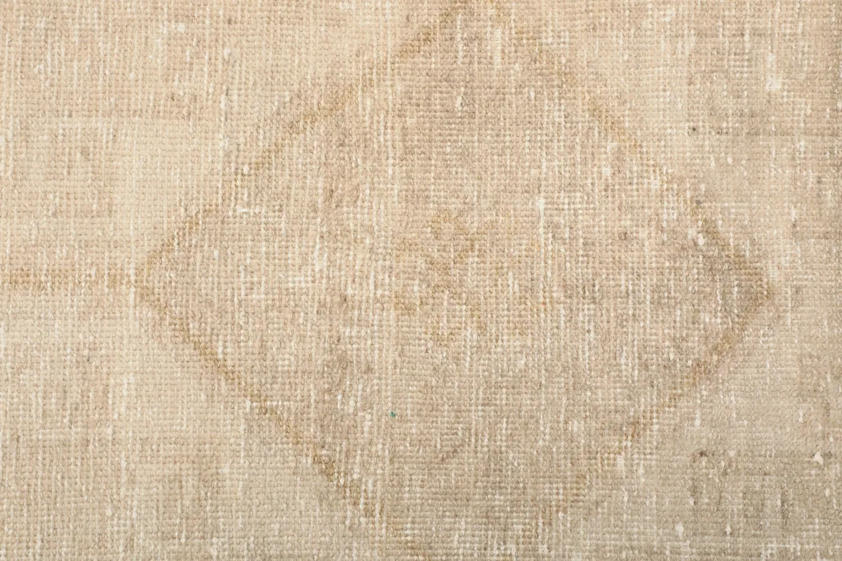 Close-up of a distinct diamond-shaped motif within the ivory runner's geometric design
