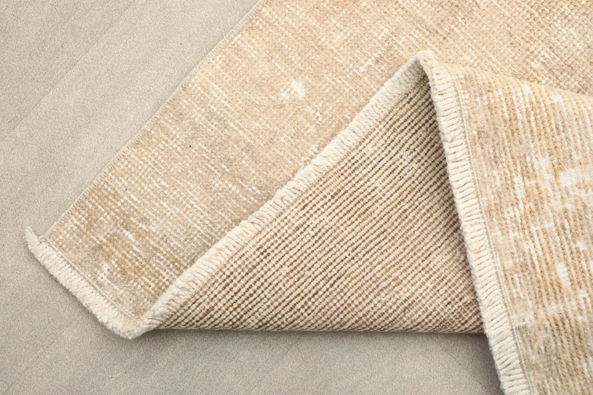 Corner of the runner folded to show the hand-knotted wool pile on a cotton foundation from the back