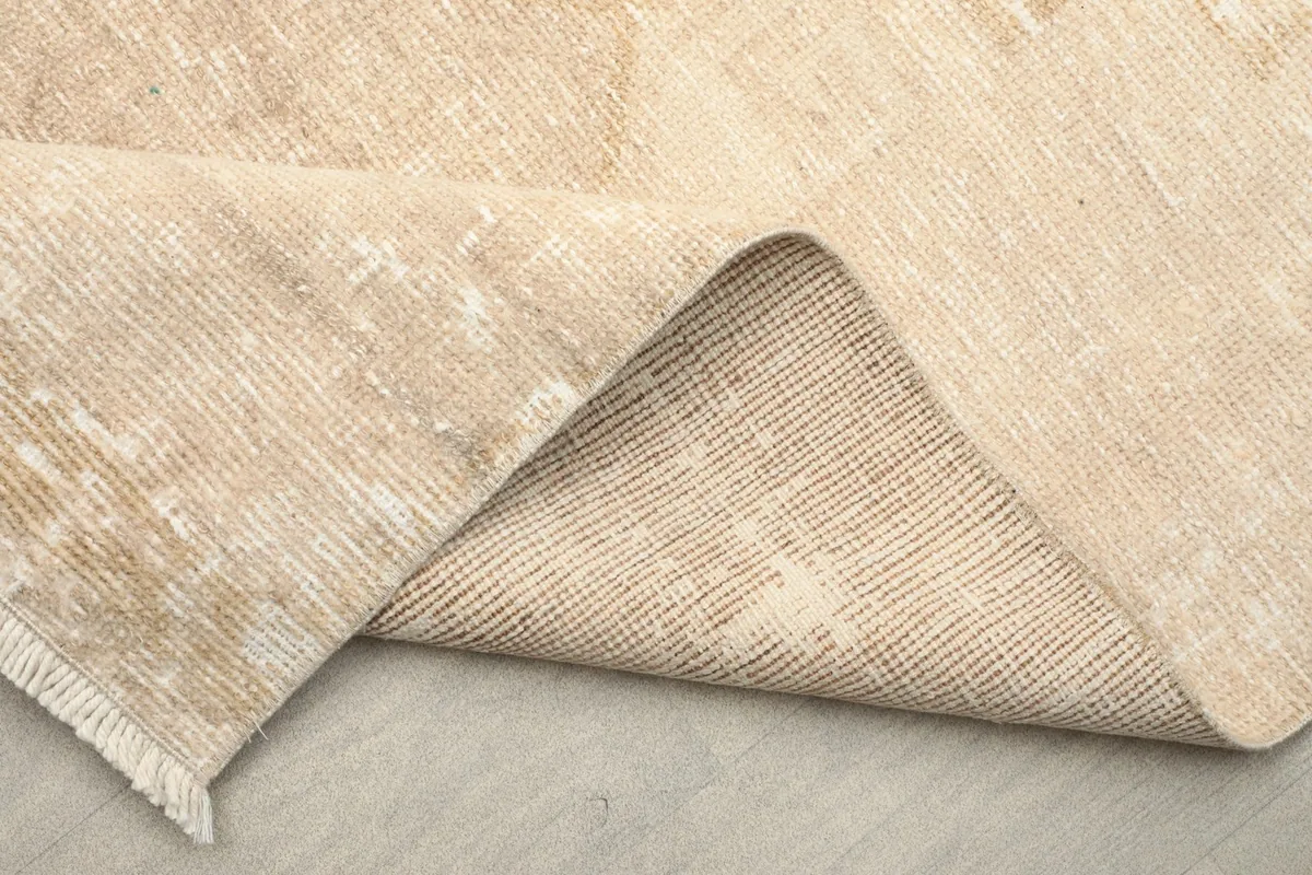 View of the rug's underside and pile, demonstrating its construction and vintage character