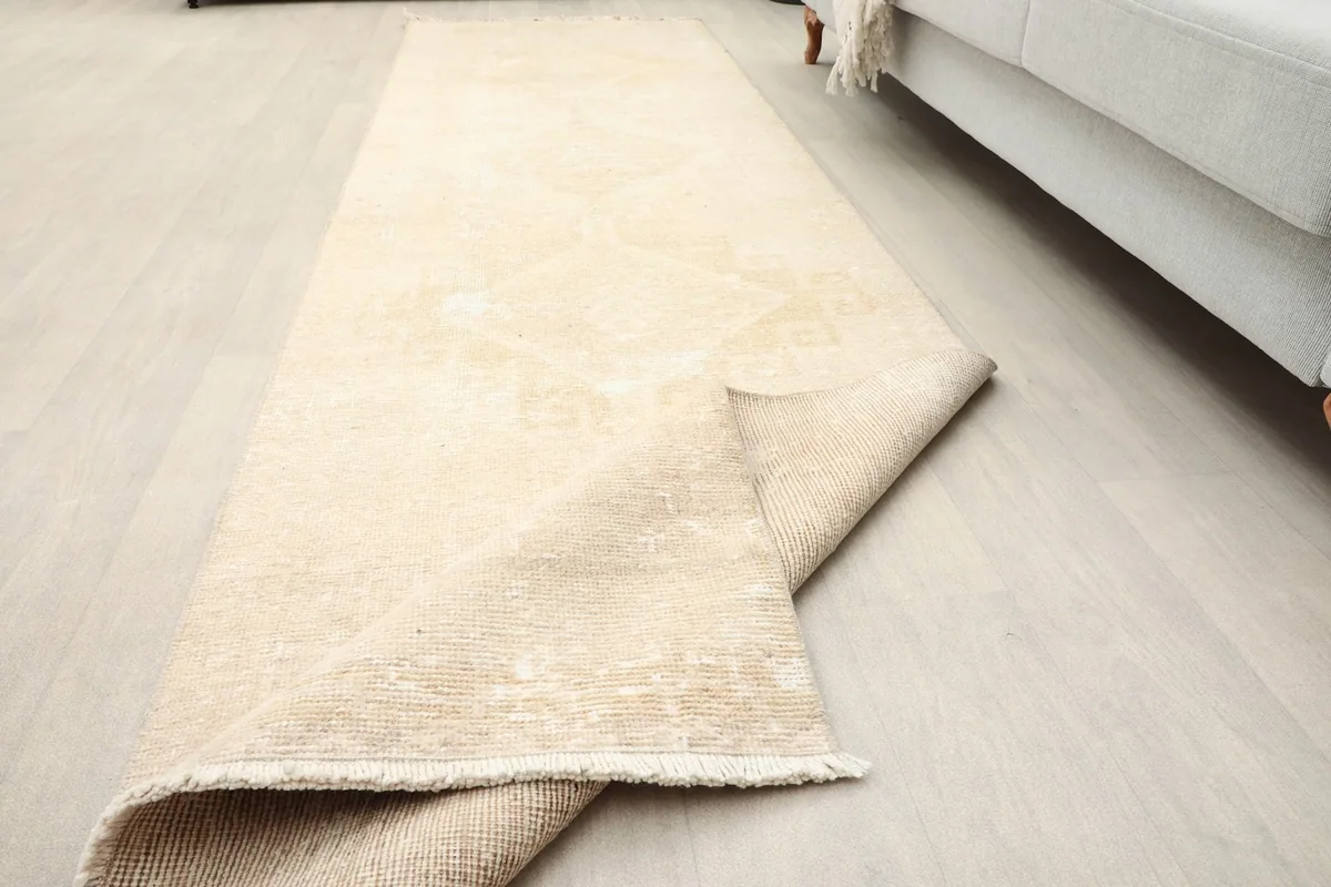 The ivory runner partially folded, indicating its flexibility and the texture of the wool