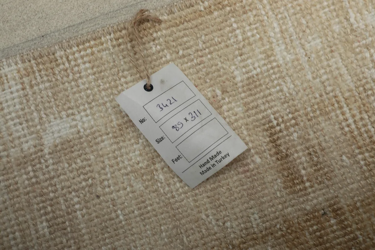 Close-up of the rug's label, showing 'Hand Made in Turkey' and size '89 x 311 cm' on the reverse