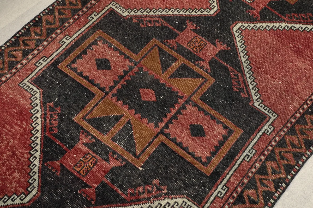 Detailed view of the intricate black, red, and gold tribal motifs within the runner
