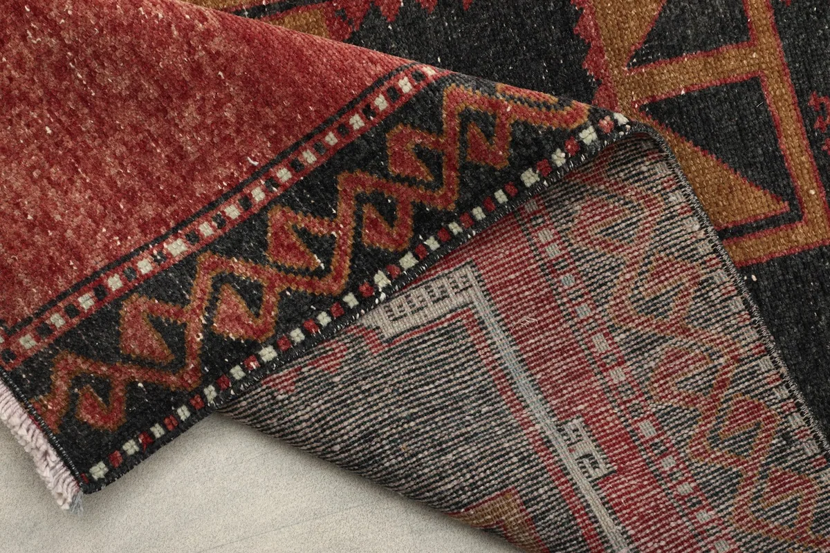 View of the rug's reverse side, showing the hand-knotted construction and foundation