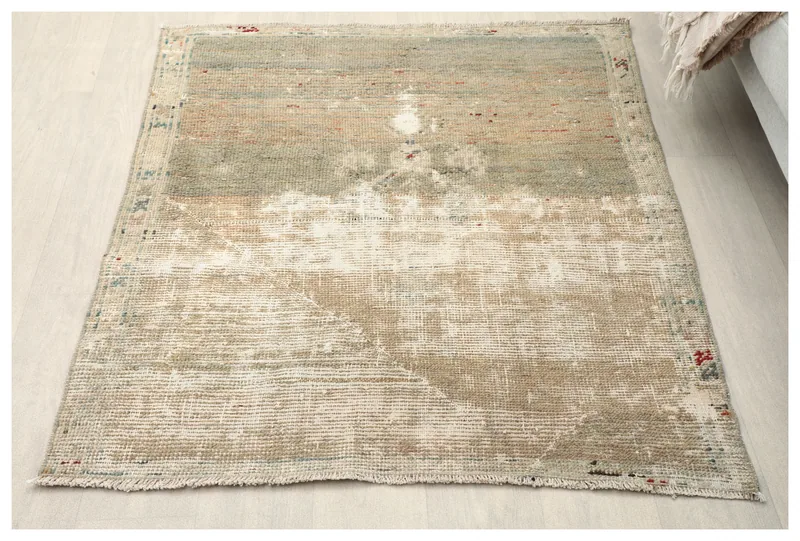 Overhead view of the 4x4 distressed green and beige vintage Anatolian rug