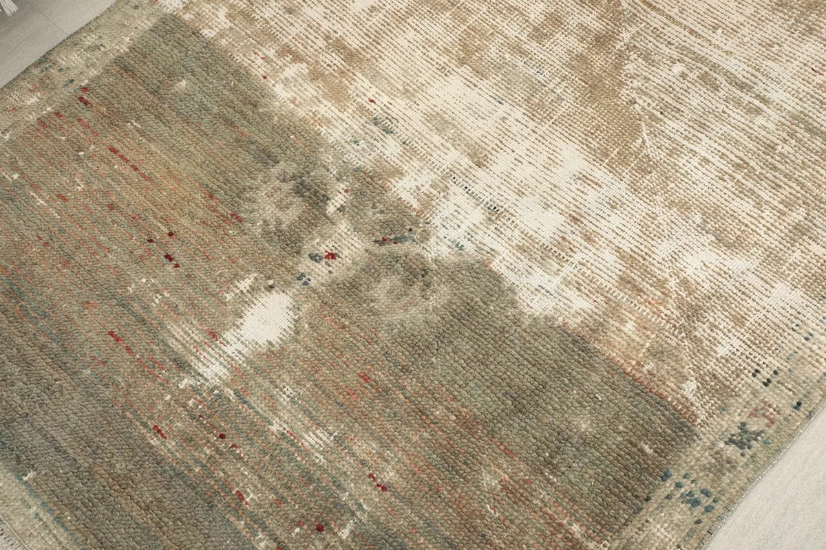 Close-up of the distressed wool pile, showing areas of wear and original colors