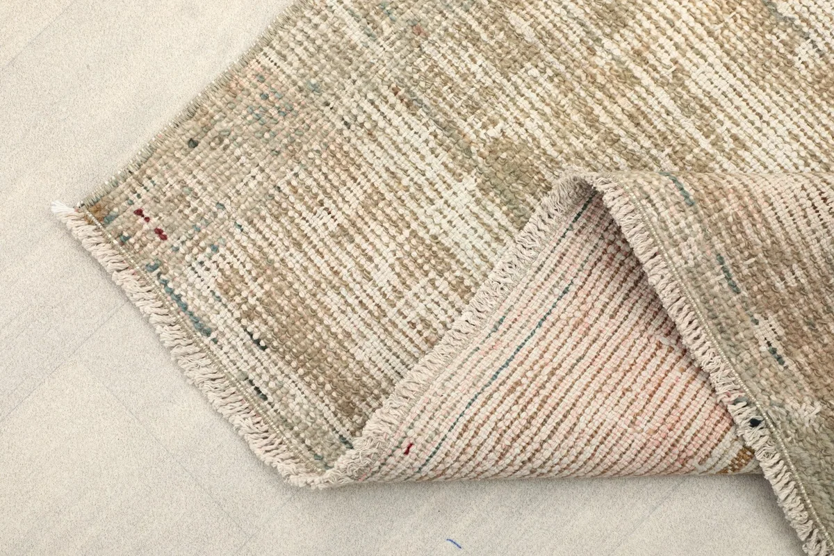 Folded corner of the rug, showing the wool pile and cotton foundation