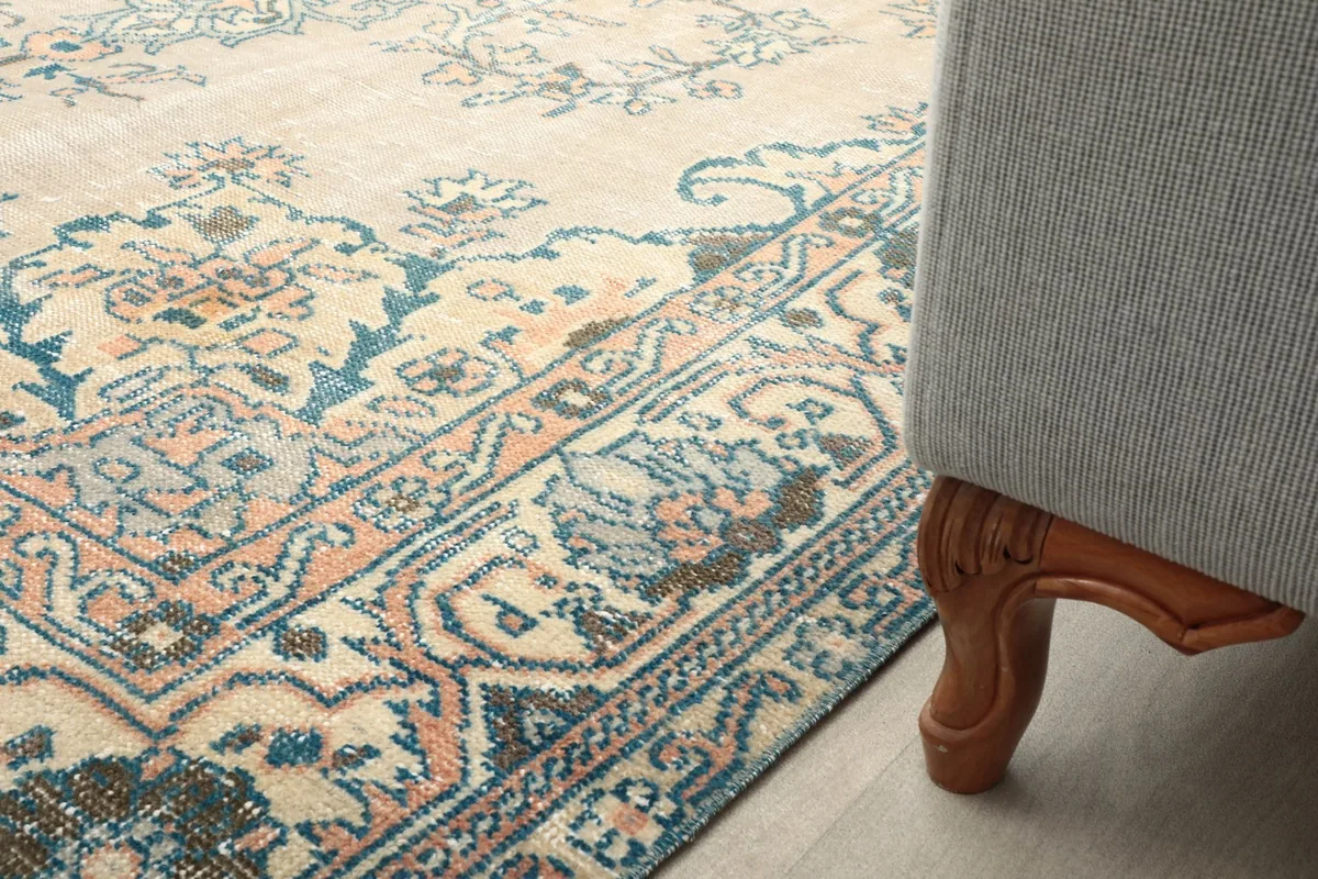 Close-up of the rug's pattern and colors under a sofa leg, showing room integration.