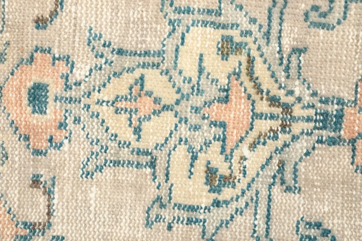 Detailed view of the low wool pile and hand-knotted texture, showing color variations.