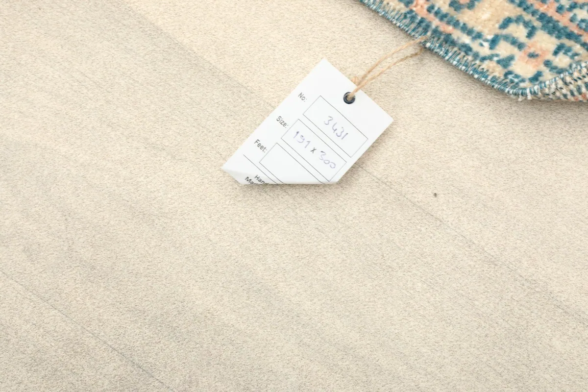 Rug tag with size information 191x300 cm on a light wooden floor.