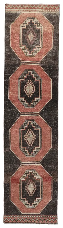 Full top view of the vintage Anatolian runner rug with rust octagons and black field.