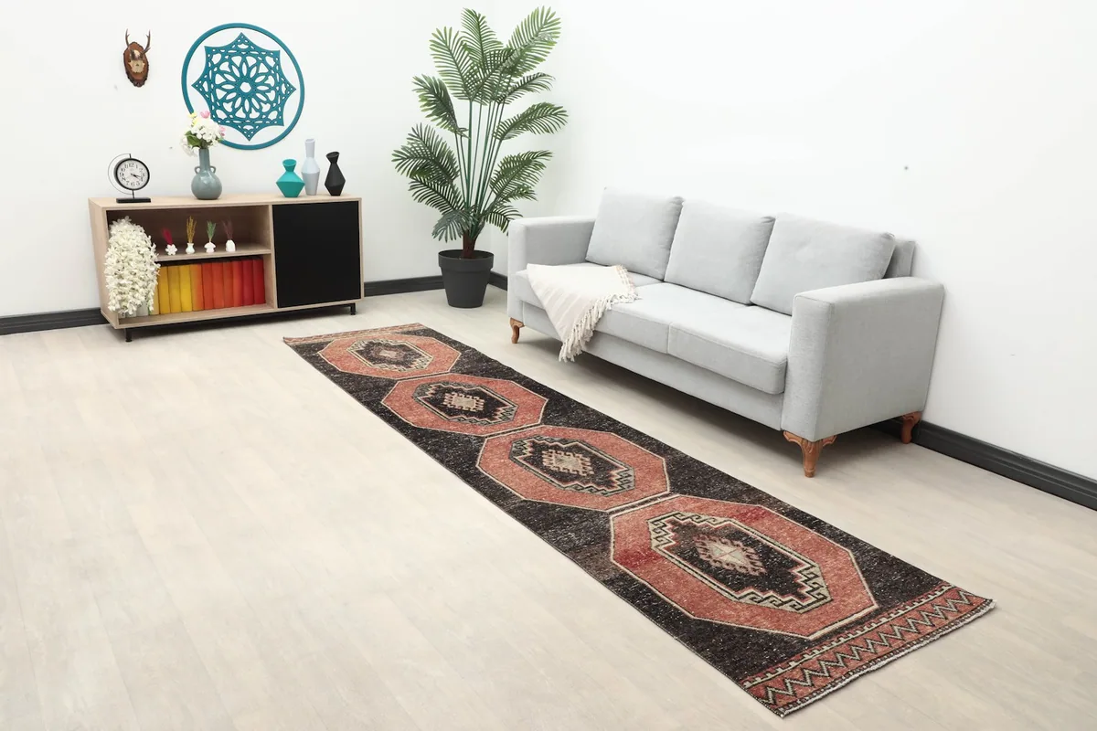 Long view of the hand-knotted runner rug in a room, showcasing its length and pattern.
