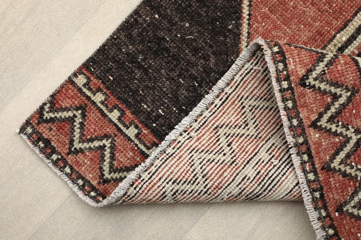 View of the back of the runner rug, showing the cotton foundation and hand-knotted construction.