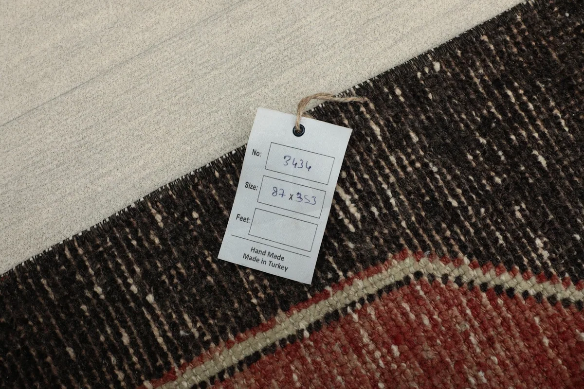 Tag with rug details, including size 87 x 353 cm, laid on the rug's surface.