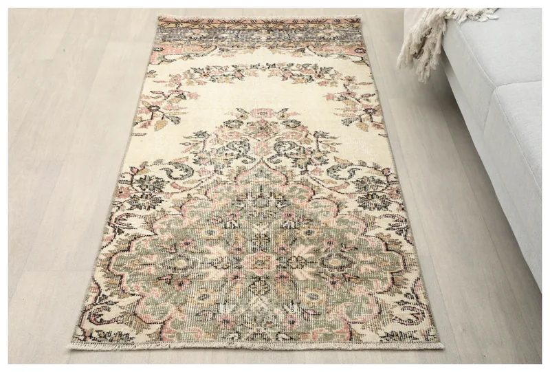 Full top view of the 2'7" x 5'3" vintage Anatolian rug with ivory, rose, and green floral patterns