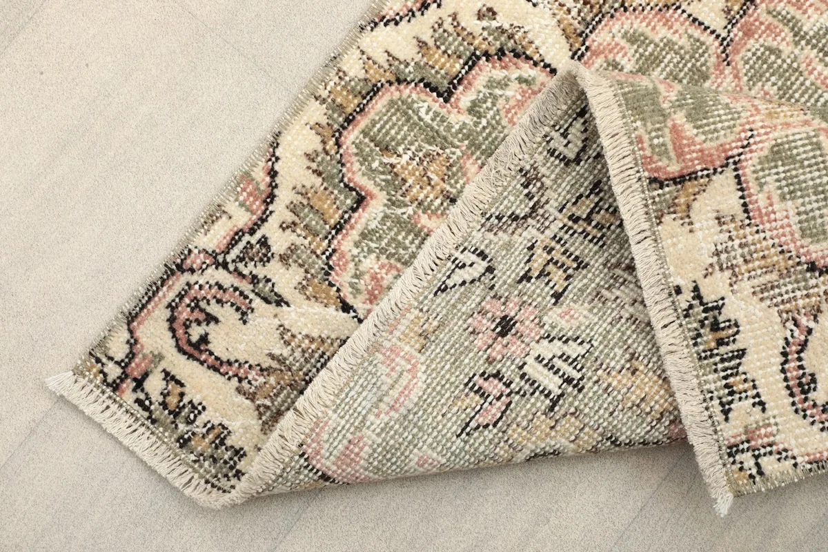 Corner of the rug folded to show the reverse side and hand-knotted construction