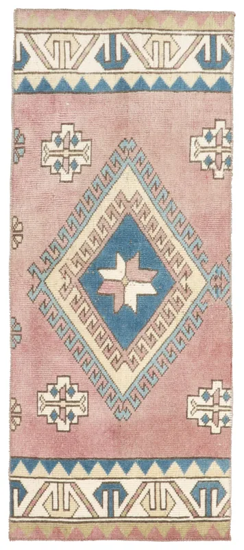 Full overhead view of the 2x5 rose and blue vintage Anatolian wool rug on a white background.